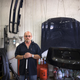 Steve Hewkin, 57, poses for a portrait in his auto body shop.